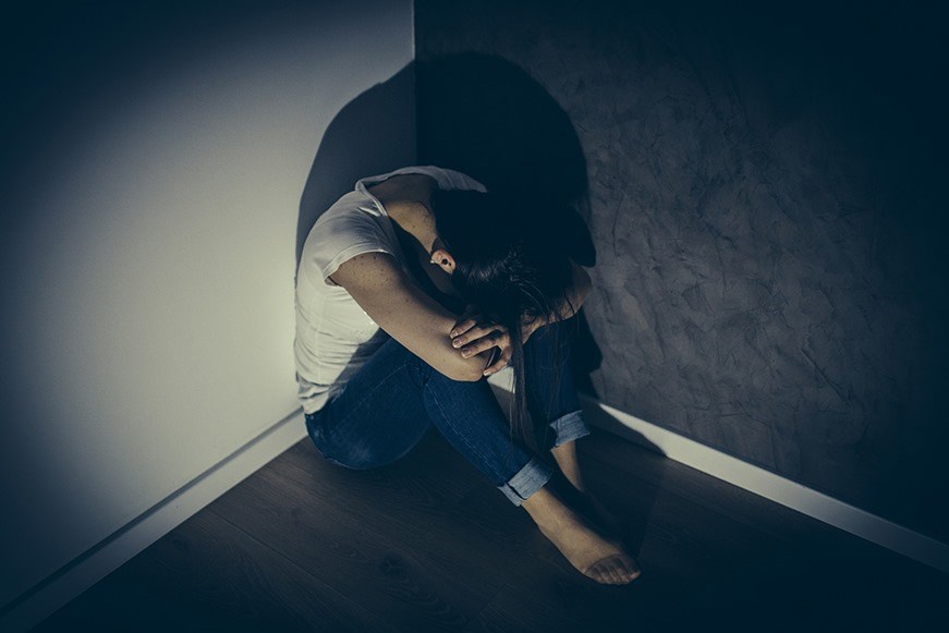 Woman huddled in corner